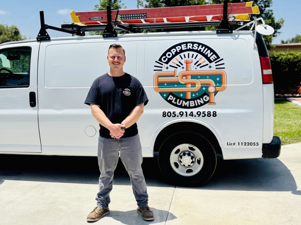 Zach Bavaro beside the Copper Shine Plumbing service van